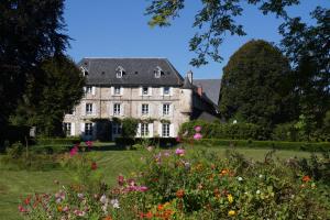 an old house in a garden with flowers at Chateau de Savennes - Caveau de sabrage in Savennes