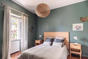 a bedroom with blue walls and a bed with two pillows at Le clos Poujeau 15 mns centre Bordeaux in Pessac
