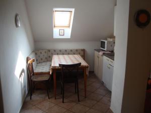 a small kitchen with a table and chairs in a room at Petrovický mlýn in Kasanice