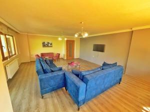 a living room with two blue couches and a table at LUSTRA GARDEN SUİTE in Trabzon