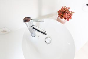 a sink with a faucet in a bathroom at Huis van Hout - architectenwoning met grote panorama tuin - design hot tub optioneel in Herk-de-Stad