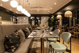 a dining room with a couch and a table and chairs at Le Celtique & Spa in Carnac