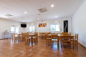 a dining room with wooden tables and chairs at Galerna Hostal in Sanxenxo