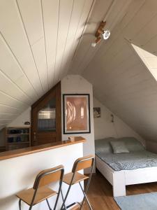 Zimmer mit einem Bett und zwei Stühlen im Dachgeschoss in der Unterkunft Privat MINI 307 in Bešeňová