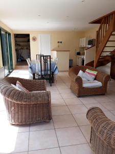 ein Wohnzimmer mit Korbstühlen und einem Tisch in der Unterkunft Maison avec jardin et plage de sable fin accessible à pied à 300m in Saint-Coulomb