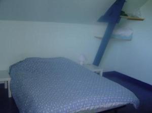 Bett in einem Zimmer mit blauem Kreuz an der Wand in der Unterkunft Maison avec jardin et plage de sable fin accessible à pied à 300m in Saint-Coulomb