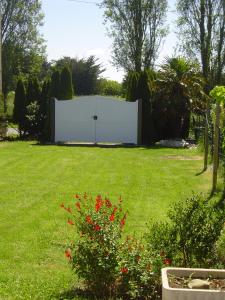 einen großen weißen Zaun mitten im Hof in der Unterkunft Maison avec jardin et plage de sable fin accessible à pied à 300m in Saint-Coulomb