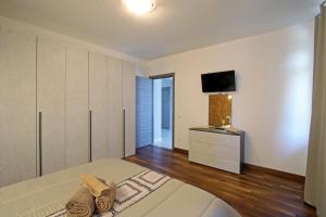 Palazzo Richard Leone في أوديني: غرفة نوم مع سرير وتلفزيون على الحائط