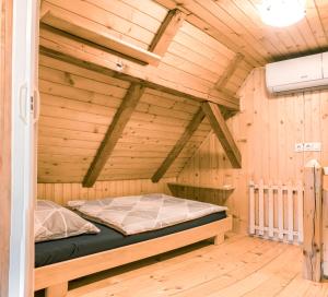 a bed in a room with a wooden ceiling at Počitniška hiška Jrga in Bovec