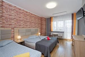 1 dormitorio con 2 camas y pared de ladrillo en Pokoje Viki, en Jastrzębia Góra