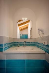 un bagno con lavandino e specchio di Palazzo San Giovanni - near Path of the Gods a Pianillo