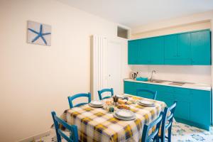 a kitchen with a table with blue cabinets at Palazzo San Giovanni - near Path of the Gods in Pianillo