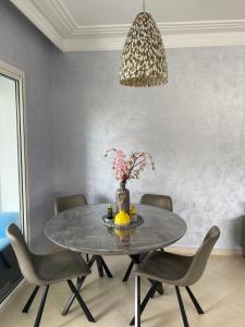 a dining room table with chairs and a vase of flowers at Marina Golf Asilah GEHEEL VERNIEUWD EN GERENOVEERD in Asilah