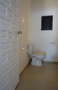 a bathroom with a white door and a toilet at Olive Branch El Chorro in El Chorro