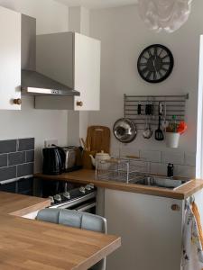 a kitchen with a sink and a clock on the wall at The Beehive - Self Contained Studio by The Sea in Exmouth
