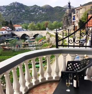 a balcony with a table and two glasses of wine at Apartments FLORA and boat cruising in Virpazar