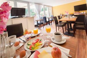 a dining room with a table with food and drinks at Hotel Marco Polo in Hamburg +28 photos