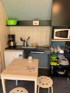 a small kitchen with a table and a microwave at Camping Club l'Air Marin in Vias