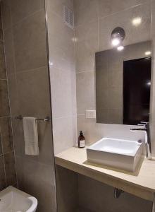 y baño con lavabo, espejo y aseo. en mstudio I Monoambiente VIRA en Puerto Madryn