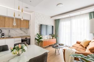 een keuken en een woonkamer met een bank en een tafel bij Exquisite Couples Delight with free bikes & parking in Split