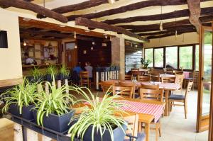 a restaurant with wooden tables and chairs and plants at Prenoćište Slapovi in Jajce