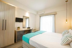 a bedroom with a large white bed and a desk at Akti Liakada Hotel in Gerakini