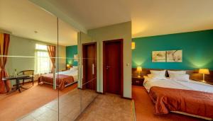 a hotel room with two beds and a glass wall at Hotel FaMil - adults only in Bansko
