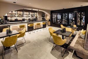 um restaurante com cadeiras e mesas amarelas e um bar em Hotel Saltauserhof em Saltusio