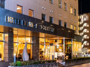 a store front of a building with a sculpture in front at Hotel Mark-1 Tsukuba in Tsukuba