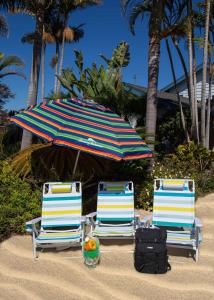 two chairs and an umbrella on a beach at Beautiful, Coastal Modern Point Loma Retreat in San Diego