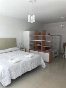 Un dormitorio con una cama blanca y un armario de madera. en Modern Studio in heart of Recoleta with pool, grill and laundry, en Buenos Aires