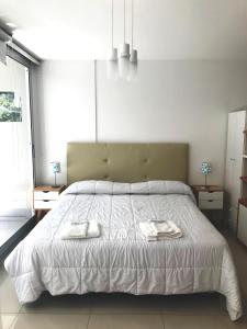 1 dormitorio con 1 cama grande y 2 toallas. en Modern Studio in heart of Recoleta with pool, grill and gym en Buenos Aires