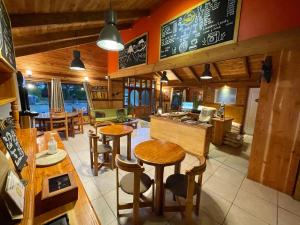 a restaurant with tables and chairs and a bar at Hostal Pucon Sur in Pucón