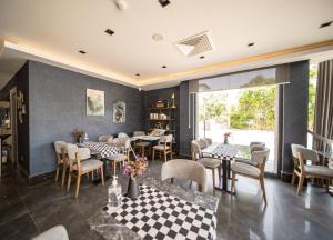 a restaurant with tables and chairs and a checkered floor at Sea Palm Otel Yalıkavak in Yalıkavak