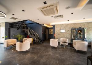 a room with chairs and a table and a staircase at Sea Palm Otel Yalıkavak in Yalıkavak