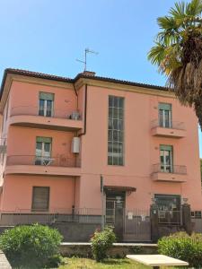 een roze gebouw met een palmboom ervoor bij Alloggio del generale in Viterbo