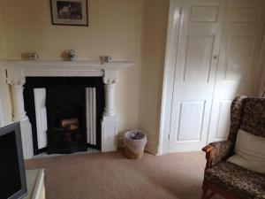 a living room with a fireplace and a door at Kirkgate House Hotel in Thirsk