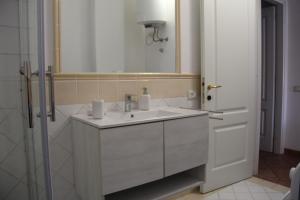 a bathroom with a white sink and a mirror at Appartamento Le Vele in Porto San Paolo