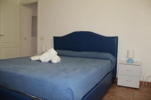 a blue bed with two white stuffed animals on it at Appartamento Le Vele in Porto San Paolo