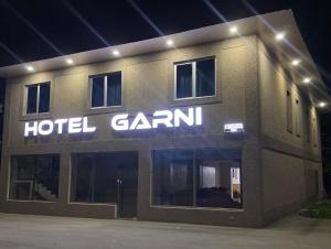 ガルニにあるHotel Garniの夜間にホテルアルマの看板がある建物