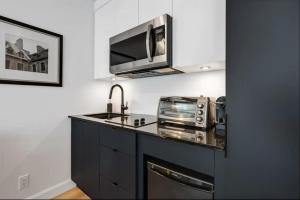 une cuisine avec un comptoir avec un évier et un micro-ondes dans l'établissement INITIAL - JAMES BOND 007 - Centre ville de Quebec, à Québec