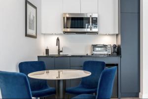 une cuisine avec des chaises bleues, une table et un four micro-ondes dans l'établissement INITIAL - JAMES BOND 007 - Centre ville de Quebec, à Québec 23 autres photos