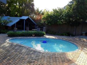 a small swimming pool in a yard with a brick patio at ZUCH Accommodation at Pafuri Self Catering - Guest Apartment in Polokwane