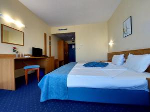 a hotel room with a large bed and a desk at Aquamarine Hotel - All Inclusive in Sunny Beach