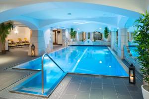 a large swimming pool in a hotel with a blue ceiling at Sporthotel Cristall in Fulpmes