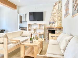 a living room with white furniture and a fireplace at Villa Escaleta Costa dorada piscina salina y privada,barbacoa in Les tres Cales