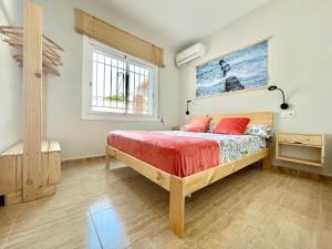 a bedroom with a bed with red sheets and a window at Villa Escaleta Costa dorada piscina salina y privada,barbacoa in Les tres Cales +19 photos