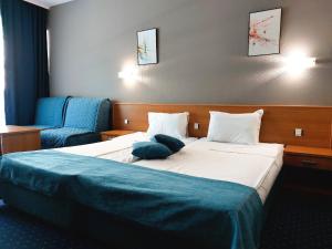 una habitación de hotel con una cama grande y una silla en Aquamarine Hotel - All Inclusive, en Sunny Beach