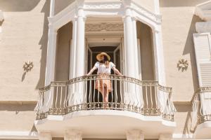 a woman standing on a balcony of a building at Le Dimore di Puglia - Palazzo Ladogana in Monopoli