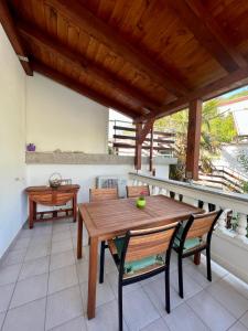 a wooden table and chairs on a balcony with a wooden ceiling at Apartments Matušan in Rab
